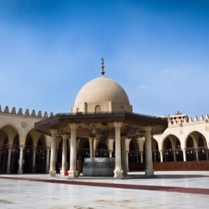 The vast, open courtyard and arcades of the Amr Ibn Al-Aas Mosque in Old Cairo, showcasing its traditional Islamic architecture