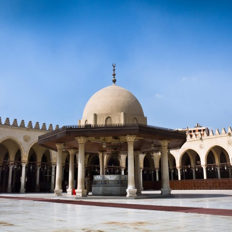 The vast, open courtyard and arcades of the Amr Ibn Al-Aas Mosque in Old Cairo, showcasing its traditional Islamic architecture